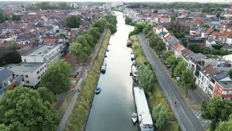 Antena-Descendente-Del-Canal-Que-Atraviesa-Gante-Con-Barcazas,-Puentes-Y-Casas.