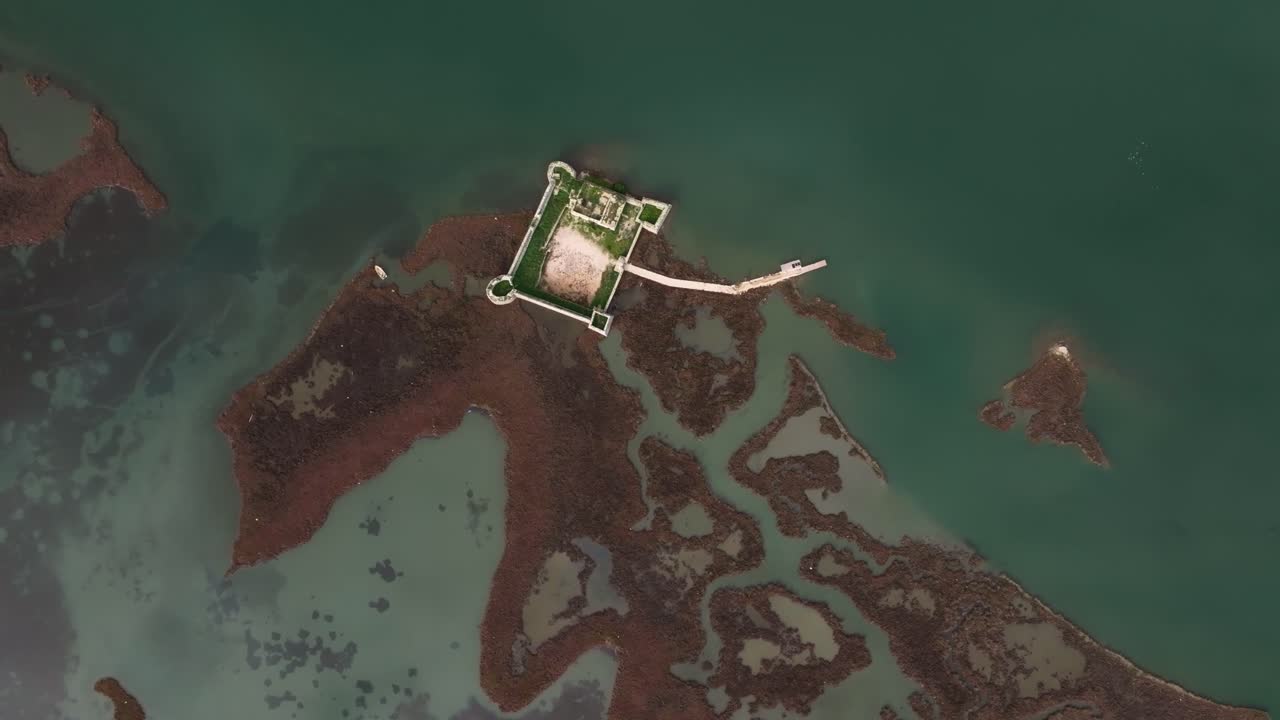 Aerial angle of a hidden castle reflecting in Lake Butrint’s waters