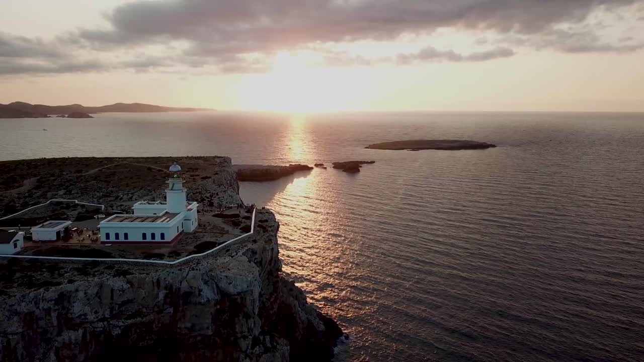 puesta de sol en el faro de cabo cavalleria en menorca, españa - toma aérea de drones