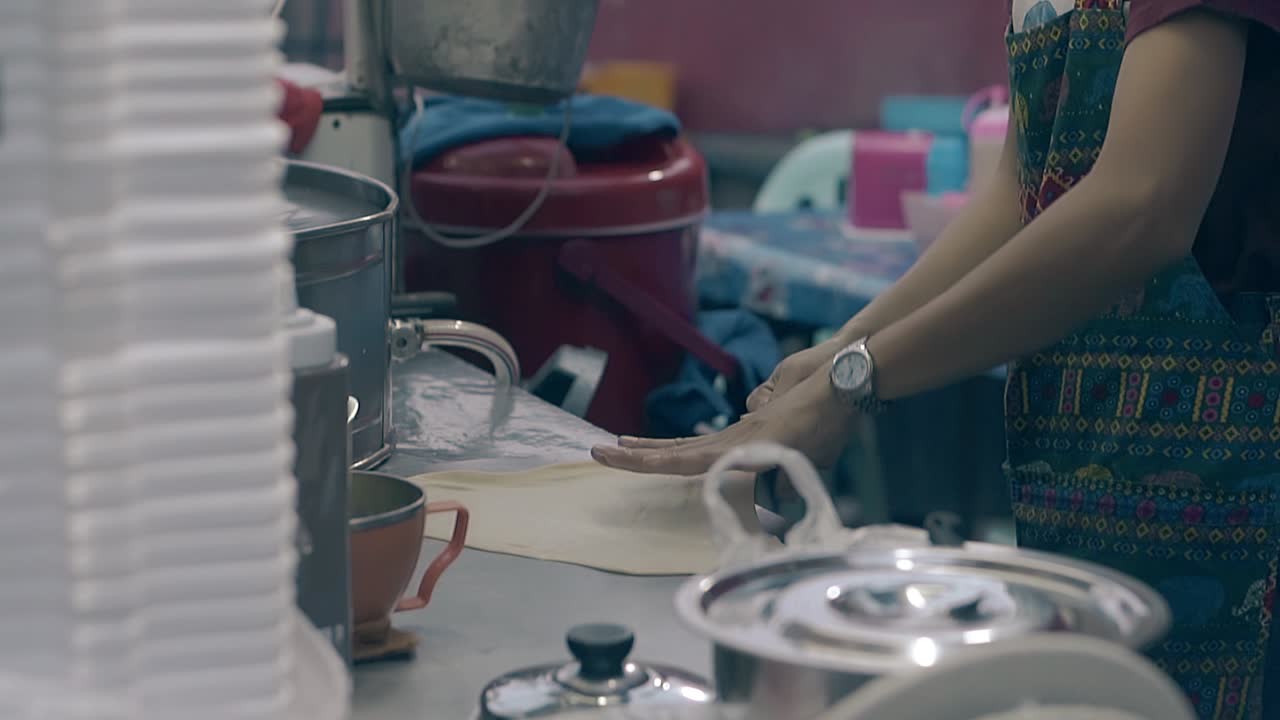 el joven jefe cocina panqueques delgados en la estufa en una cafetería en cámara lenta.