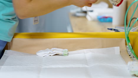 nurse looking through baby clothes. cute little garment is laid on the special table. close up.