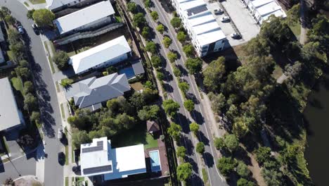 Aerial-view-of-a-divided-road-in-a-residential-suburb-near-a-manmade-lake-in-Australia