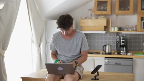 man working on laptop in a kitchen