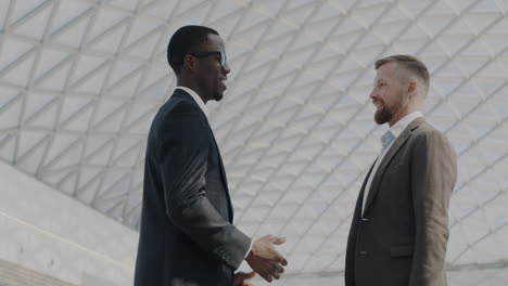 businessmen shaking hands in modern building