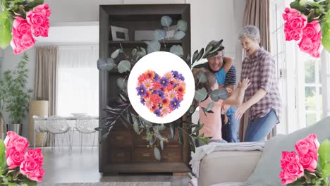 animation of flower heart in round shape over happy caucasian grandparents and granddaughter