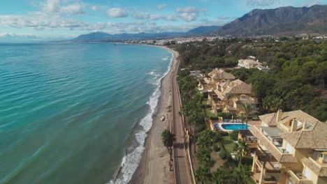 Aerial-moving-forward-and-tilting-up-into-the-horizon-to-reveal-the-coastline-near-Marbella,-Spain