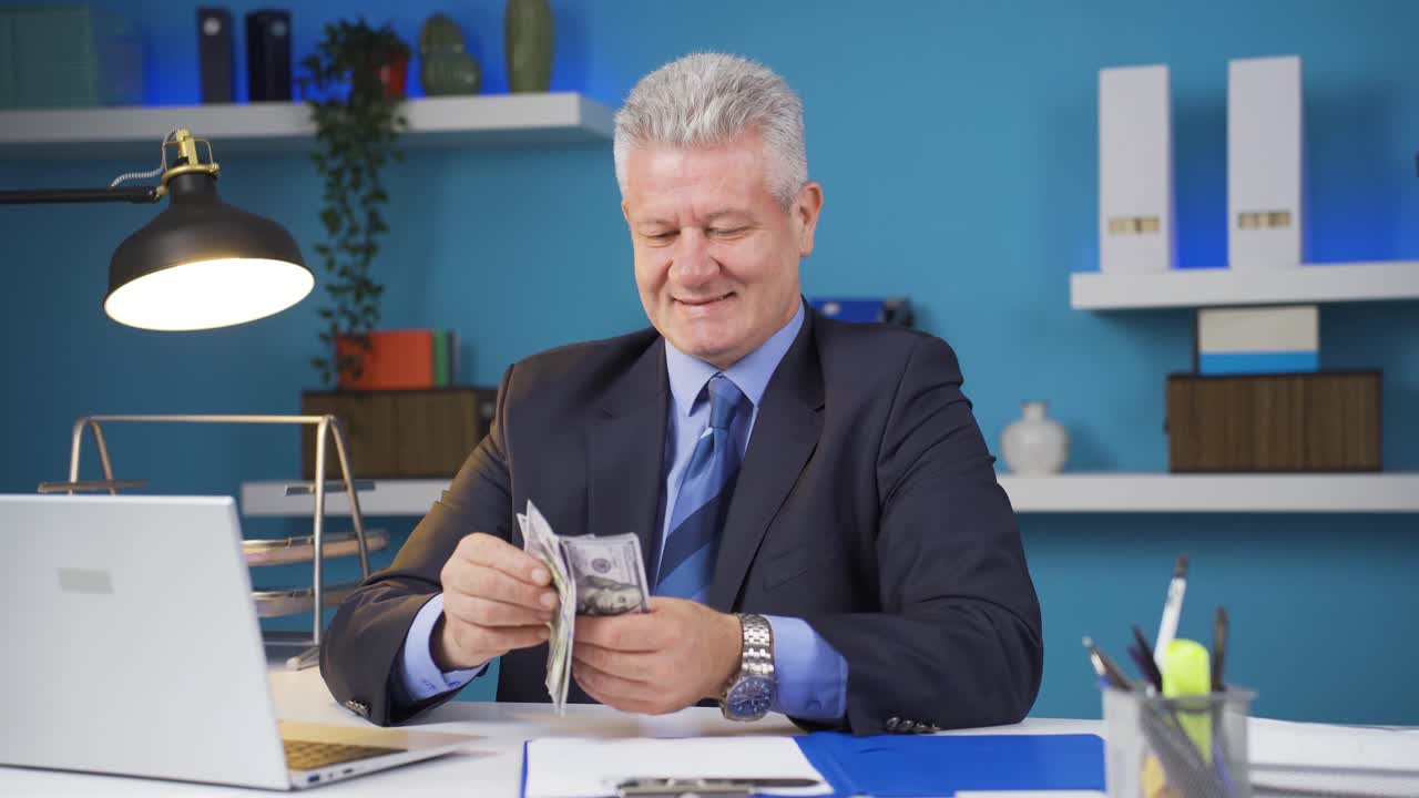 카메라를 쳐다보며 돈을 세는 사업가