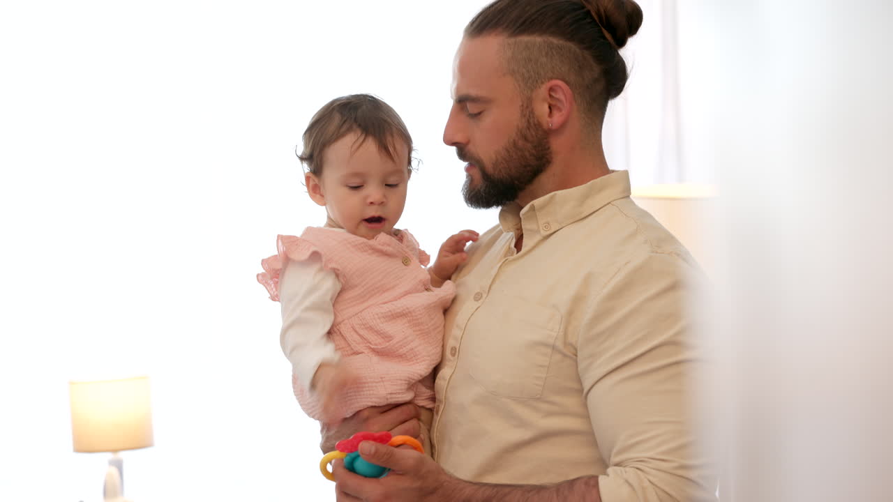 Pai conversando com bebê recém-nascido, com brinquedos