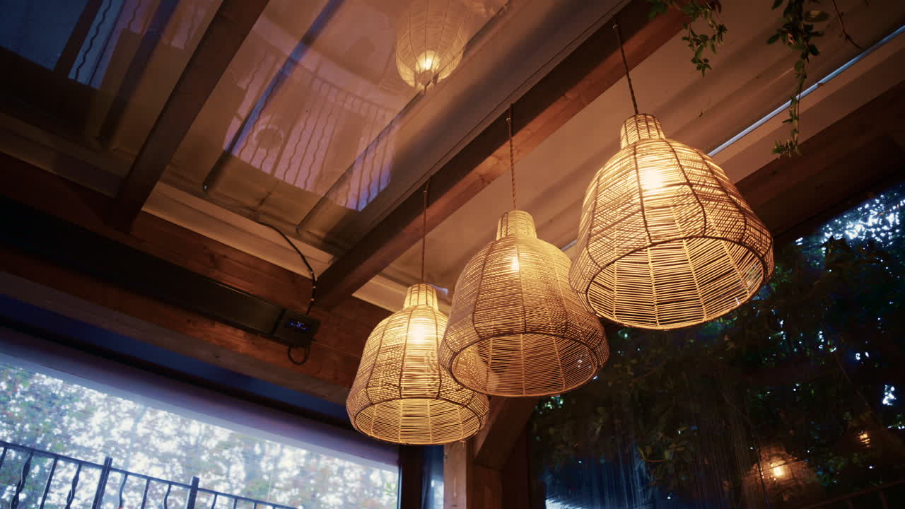 Close up of glowing woven pendant lights hanging in a stylish restaurant on the Cote d'Azur