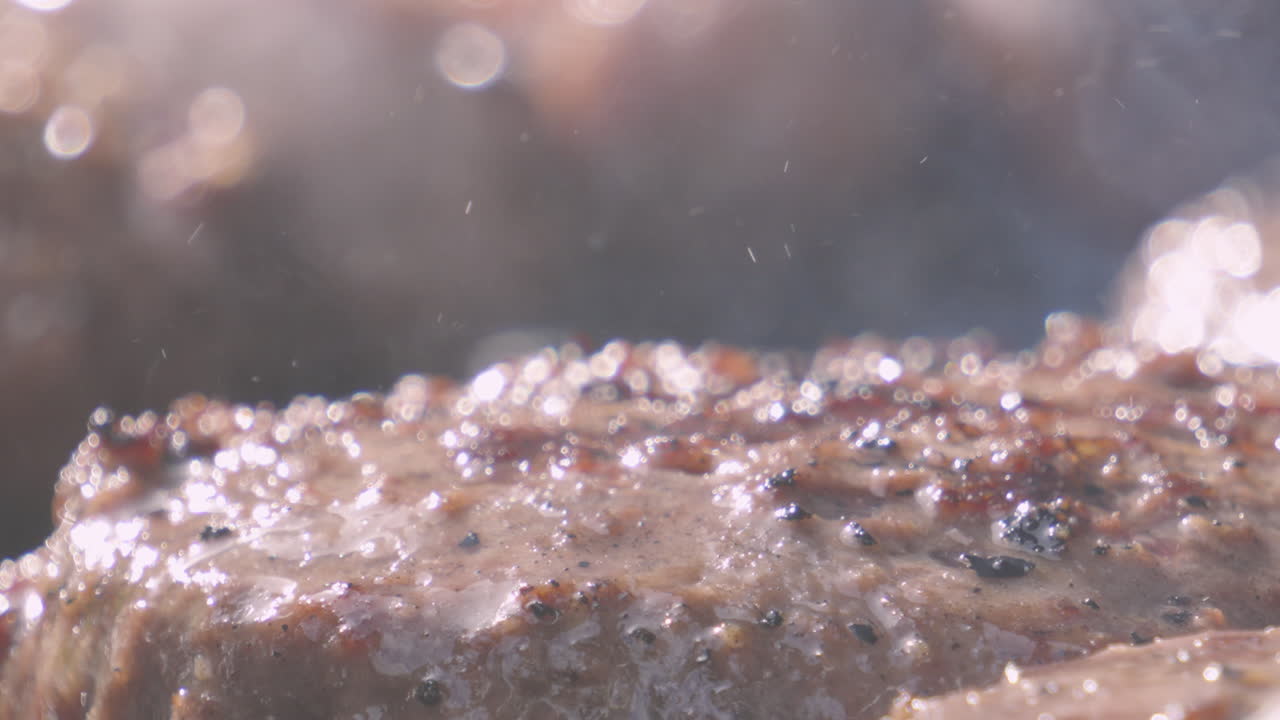 Heat Distorted Close Up View of Juicy Burger Cooking on BBQ in Bright Sunlight. High Protein Tasty Summer Outdoor Food. Filmed on Cinema Camera.
