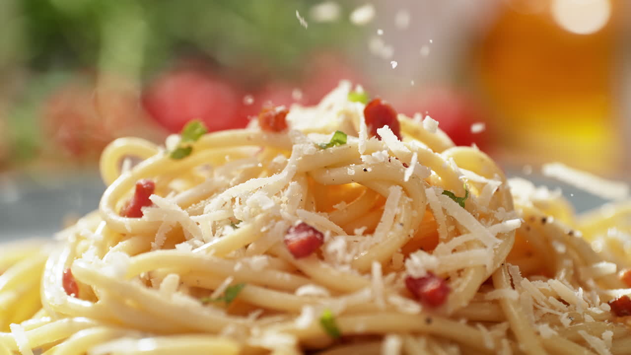 Grating Cheese onto Freshly Prepared, Served on a Plate, Spaghetti Carbonara with Pancetta, Egg, Black pepper, and Chopped Herbs