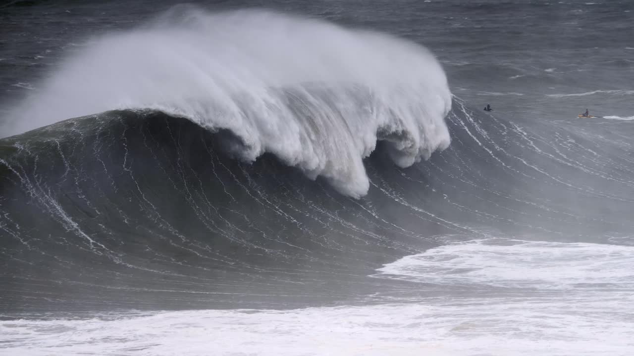 나자레에서 거대한 파도가 터져 제트 스키 라이더가 뒤에서 느린 동작 4k를 드러니다.