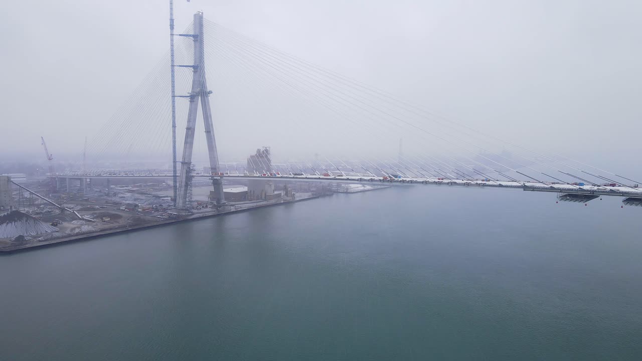 Gordie Howe International Bridge construction over Detroit River on foggy winter day