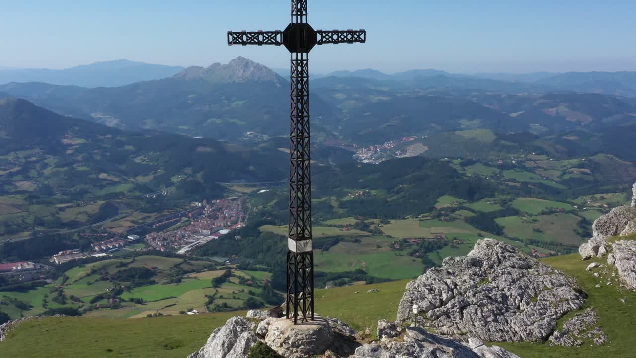 vista aérea de drones de una gran cruz de hierro en la cima de una montaña en el país vasco