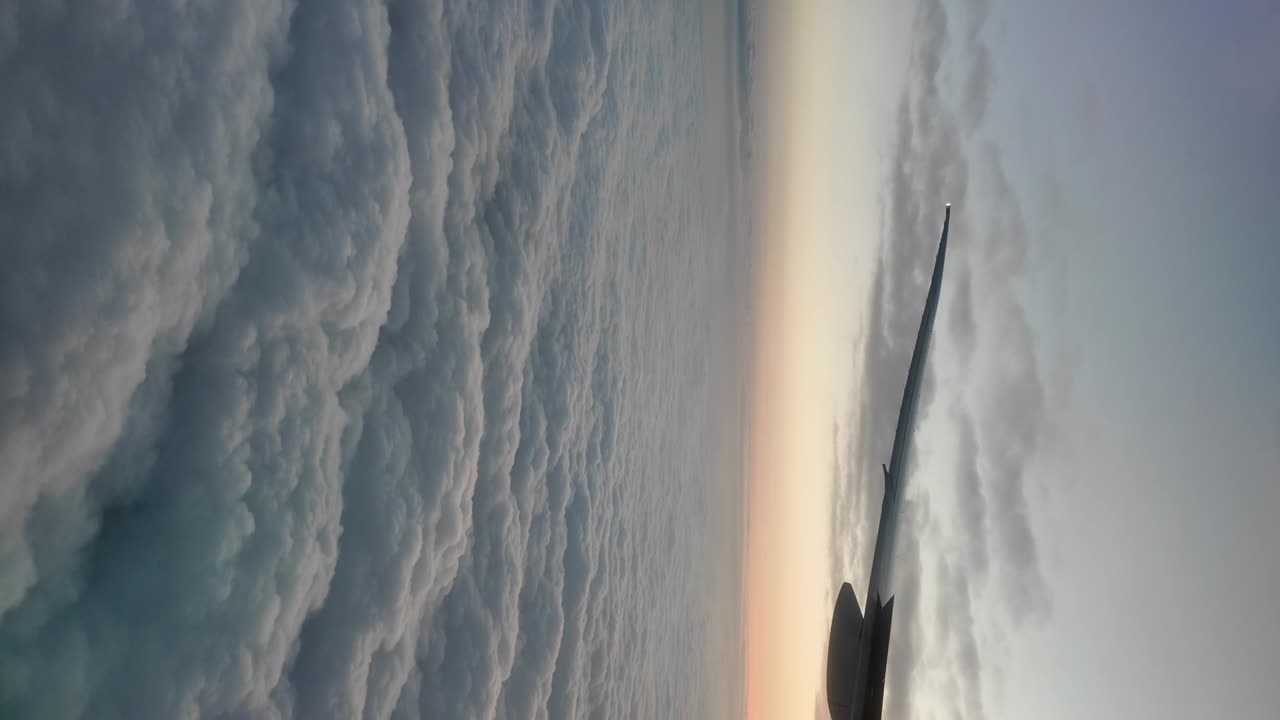 View from an airplane above the clouds at sunset