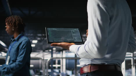close up of programmer swiping on tablet display in data center, checking code