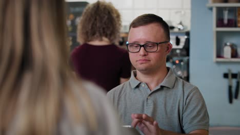 Kaukasischer-Mann-Mit-Down-Syndrom,-Der-Im-Café-Mit-Einem-Digitalen-Tablet-Bestellt.