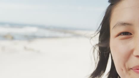 portrait of happy biracial woman smiling at beach, in slow motion, with copy space