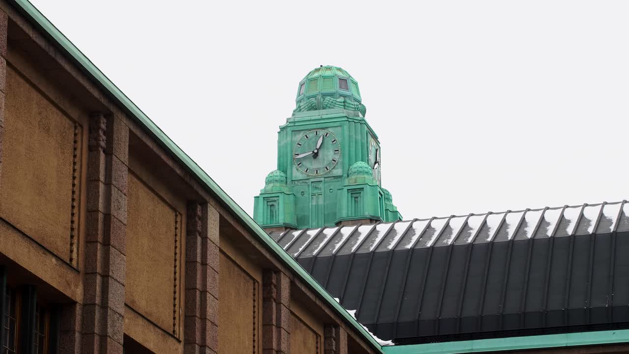 torre del reloj turquesa mirando hacia la estación de tren, helsinki, día nublado