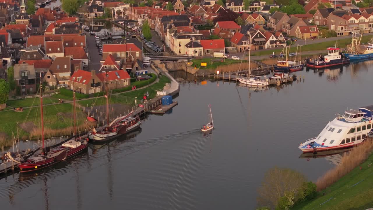 Scatto aereo del villaggio olandese di Makkum con barche e tetti storici.