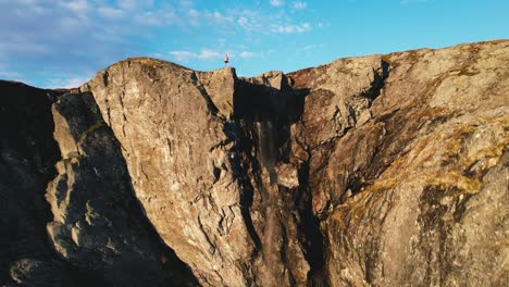 pedestal aéreo sobre un acantilado iluminado por el sol en el parque nacional hardangervidda, eidfjord, noruega