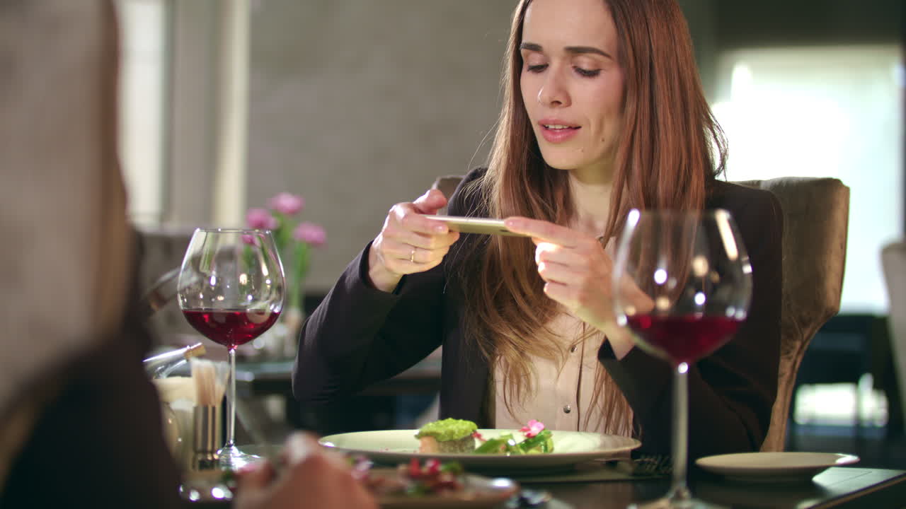 Mujer de negocios tomando fotos de comida en el teléfono inteligente en el restaurante
