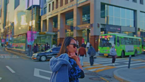 beautiful asian oriental female girl woman model in big city town urban street area with sunglasses and cellphone talking and walking crossing road