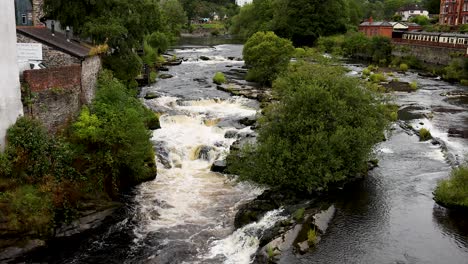 flowing river with waterfall and greenery