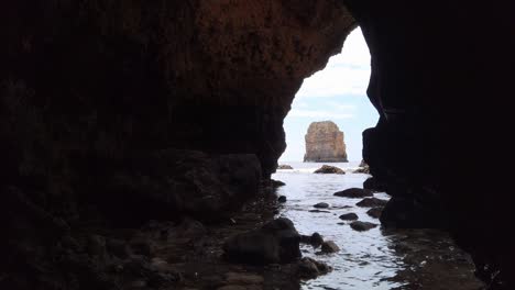 Viendo-Una-Pila-De-Piedra-Caliza-A-Través-De-La-Apertura-De-Una-Cueva-Marina-Cerca-De-Lagos,-Portugal