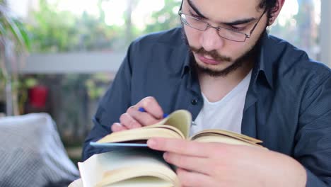 young man reading a book at home