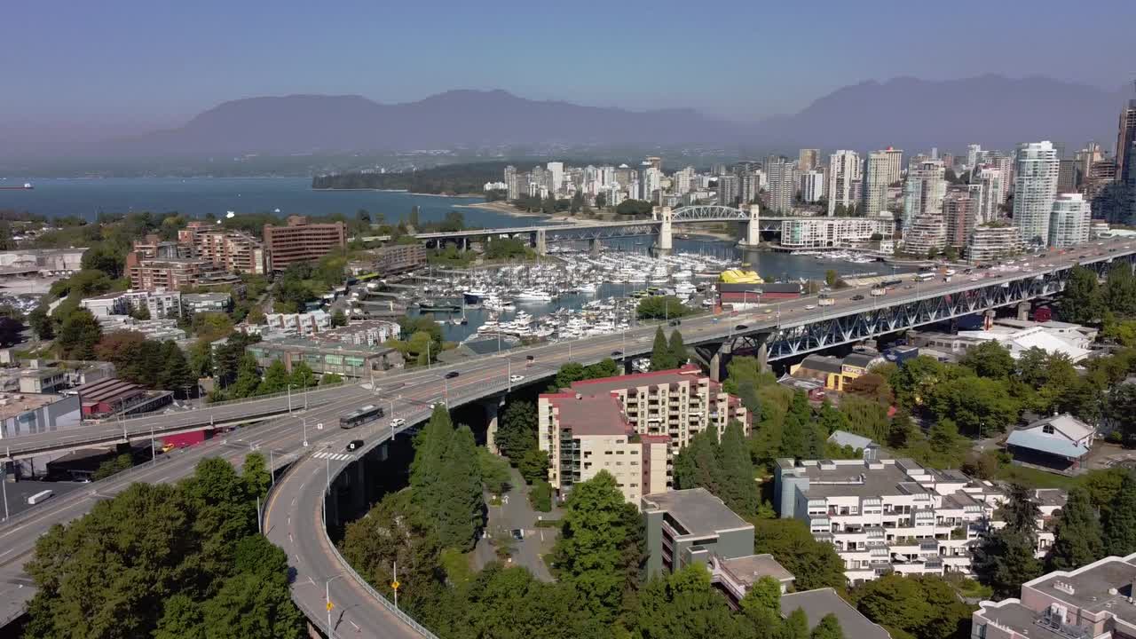 panorámica aérea sobre el puente de granville que conduce al centro de vancouver false creek se dirige a la bahía inglesa de yaletown el núcleo principal de la ciudad con un horizonte brumoso bg de las montañas del noroeste de vancouver 1-2