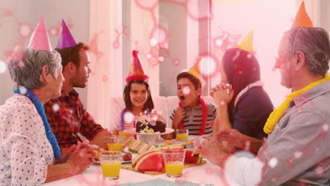 celebrating birthday, family with cake and party hats at dining table