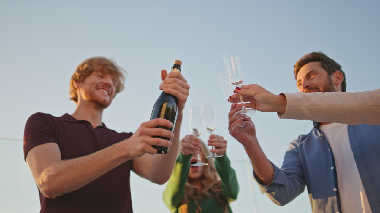 amigos con botellas de champán divirtiéndose juntos en una fiesta al aire libre.