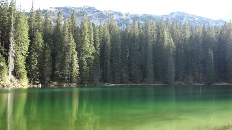 sunset reflects over green surface of zminje lake in durmitor national park, zabljak, montenegro