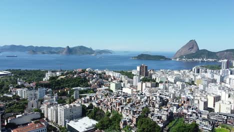 Favela,-buildings,-sea-and-Pao-de-Acucar-on-the-background---daylight-landscape-by-drone-in-Rio-de-Janeiro