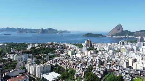 favela, buildings, sea and pao de acucar on the background - daylight landscape by drone in rio de janeiro