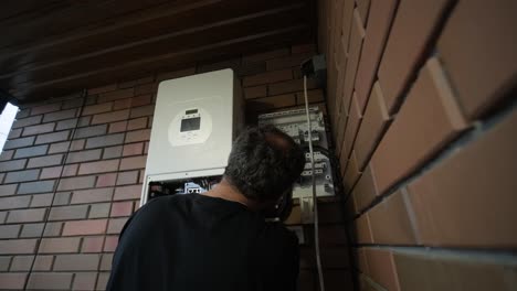 an electrician installing an inverter in a home. the image shows technical skill, modern tools, and attention to safety in electrical work