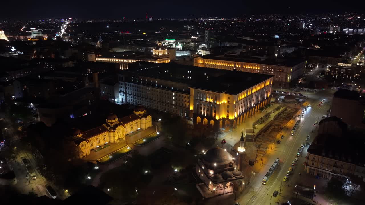 Drone orbits over Sofia’s city center at night, capturing glowing streets, illuminated buildings, and the vibrant urban nightscape from above