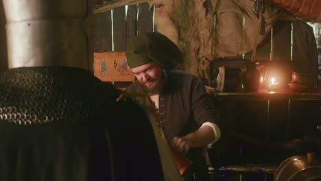 smiling bearded innkeeper offers alcohol to knight in tavern. accommodating dwarf bartender in bonnet pours drink for noble lord in hotel. fairy tale characters