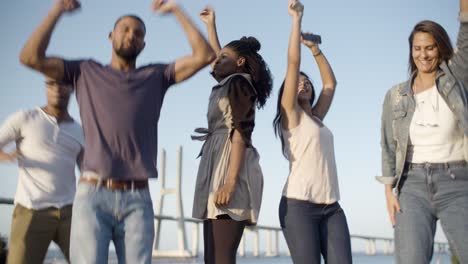 Happy-smiling-friends-dancing-and-jumping-in-park.