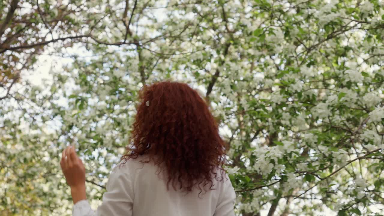 Woman enjoying spring in a blooming park