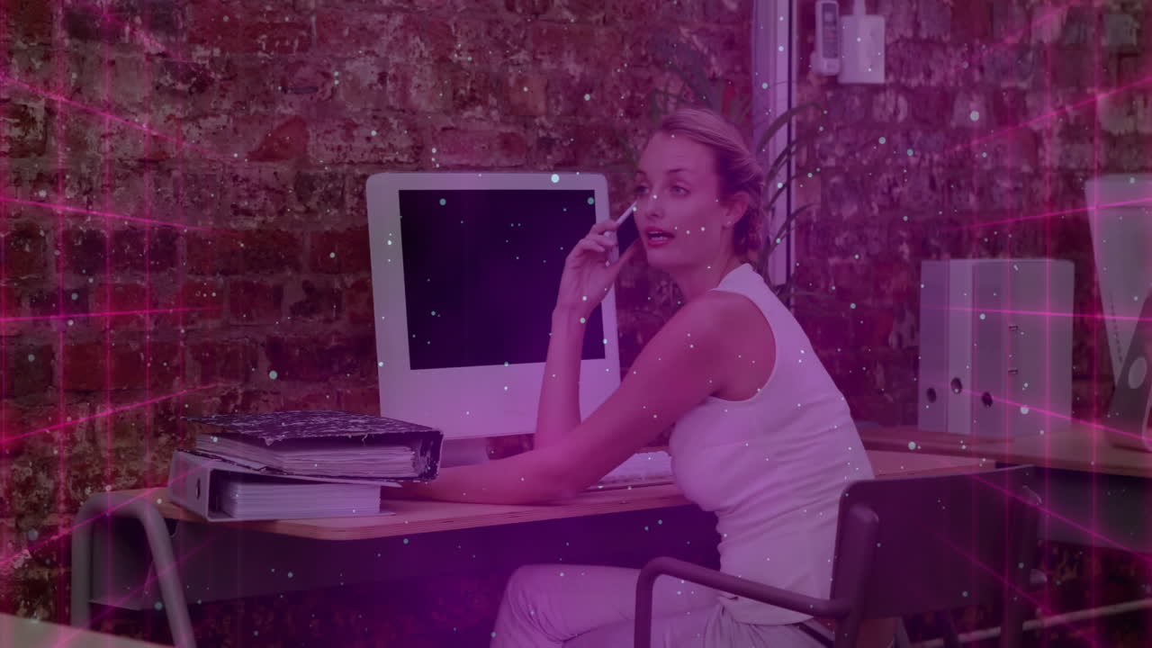 Woman speaking on smartphone in industrial office, displaying animated business charts floating