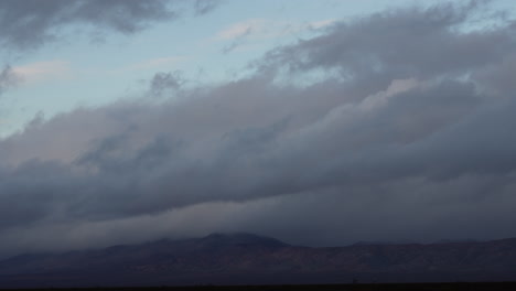 nube de tormenta que sopla en el viento sobre las montañas al amanecer - lapso de tiempo de cloudscape