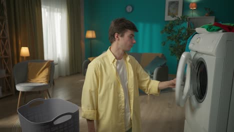young man struggling with washing machine