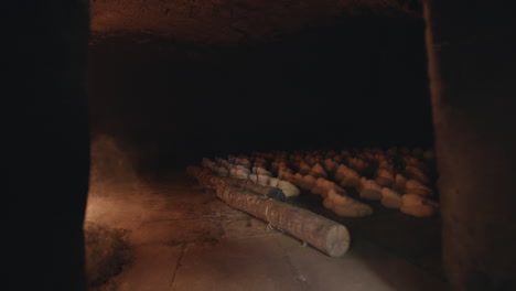 Slow-motion-footage-of-a-large-wood-fired-oven-in-Italy-with-loaves-being-baked-and-flour-being-thrown-in-the-oven