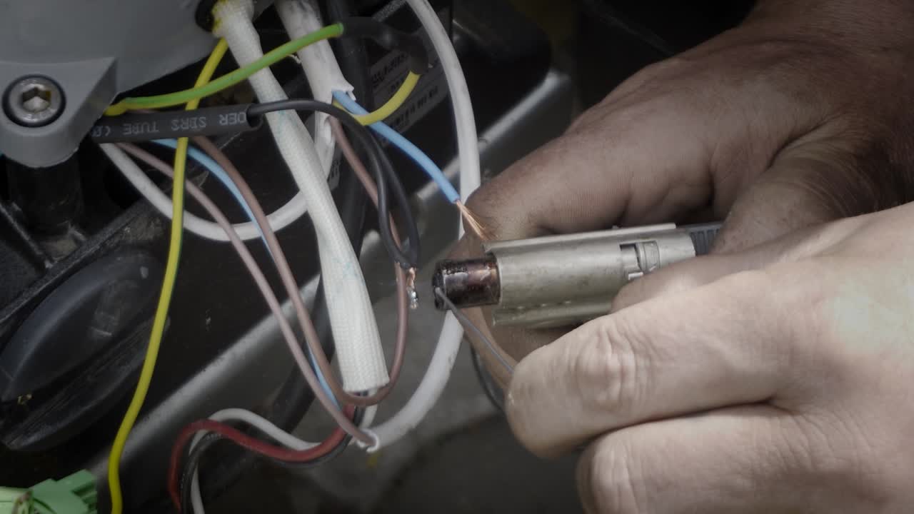 Soldering wires with a gas soldering iron, close-up.