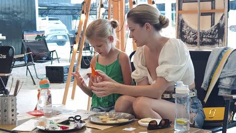 mother and daughter making cookies at a craft market