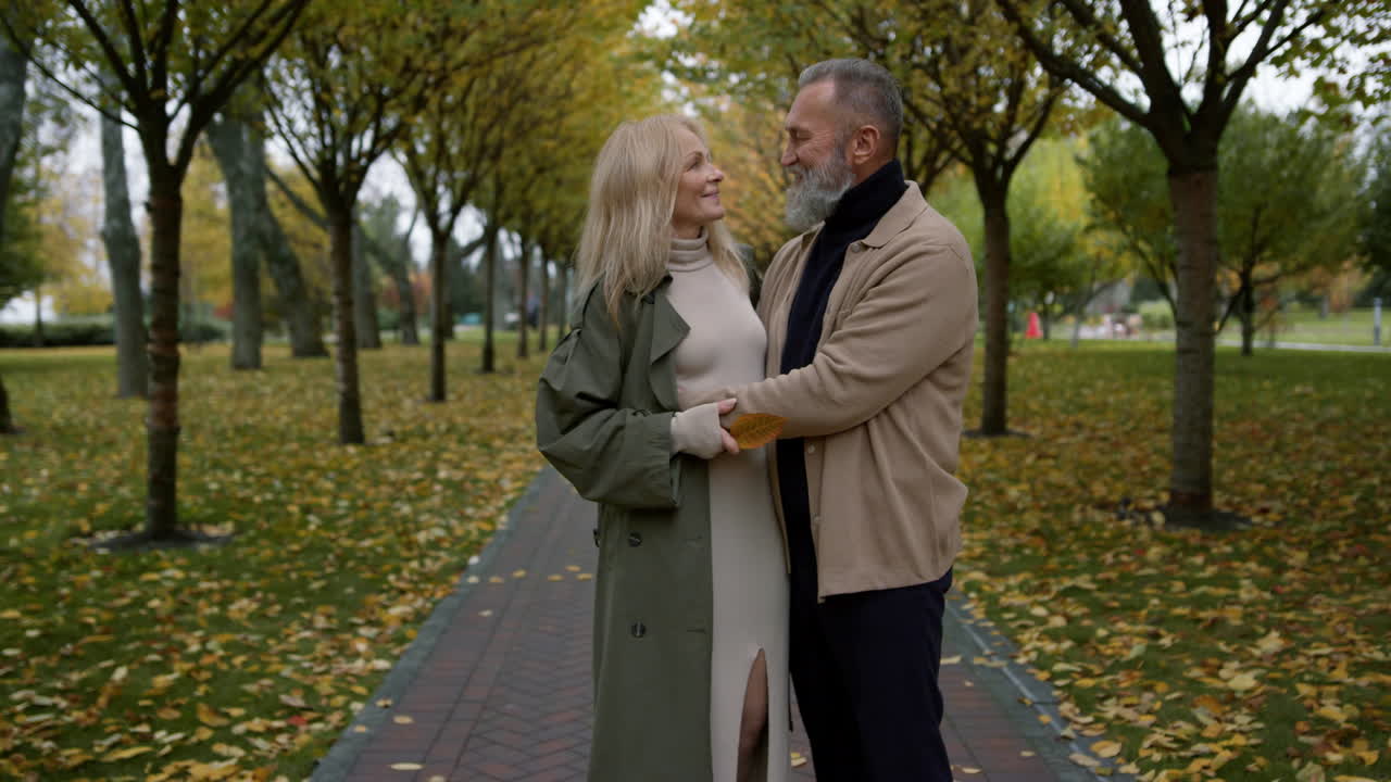 Romantic couple standing in full happiness with foliage on background.