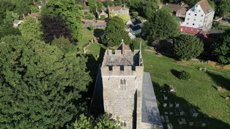 a push-in shot over trees towards the tower of st andrew's church in wickhambreaux