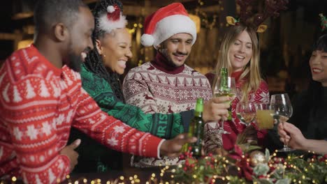 tracking shot approaching friends toasting drinks during christmas celebrations